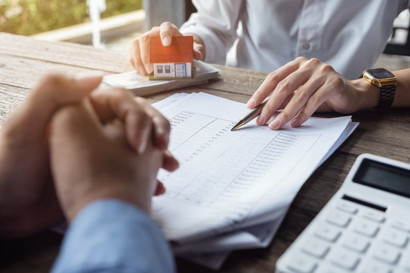 Real Estate agent showing new homeowner how to a real estate loan.