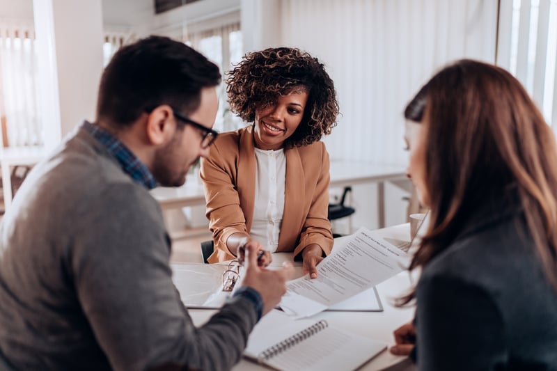 loan officer explaining a contract to two people