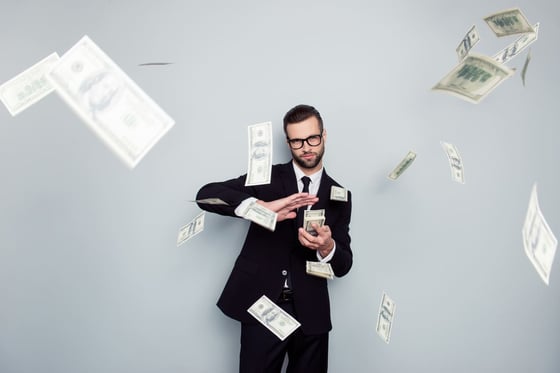 Man in a suit making it rain with hundred dollar bills from flipping commercial real estate